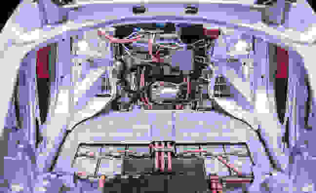 Ein Blick ins Innere eines Elektroautos mit sichtbarem Motor und elektrischen Komponenten.
