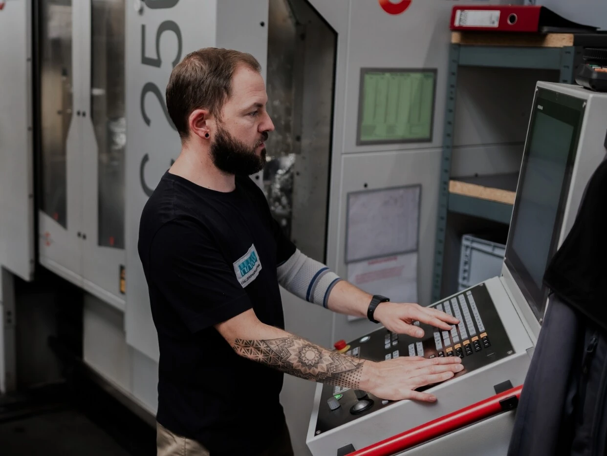 Ein Maschinenbediener steuert eine CNC-Maschine in einer Fabrik.