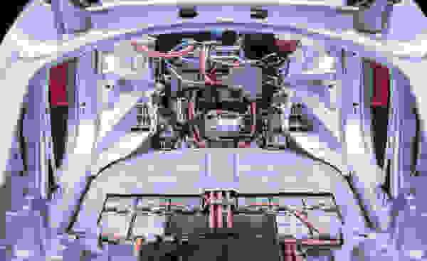 Ein Blick ins Innere eines Elektroautos mit sichtbarem Motor und elektrischen Komponenten.